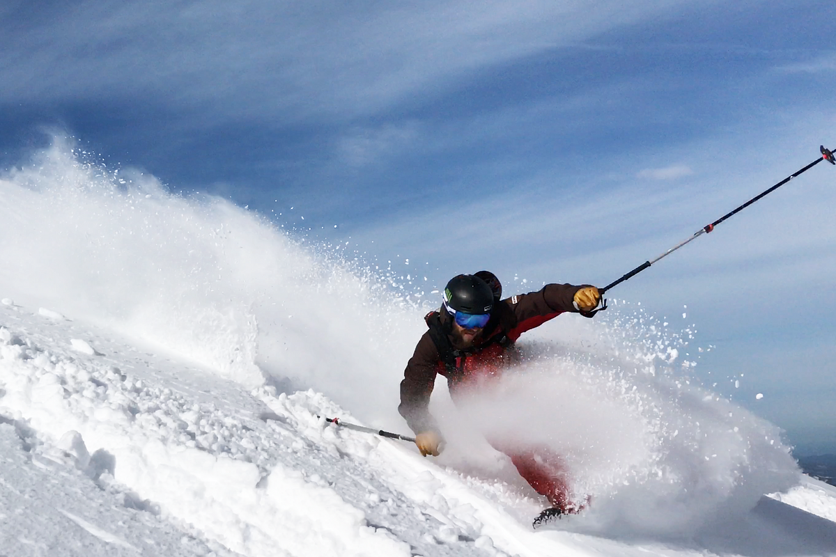 Brendan skiing against a blue sky backdrop
